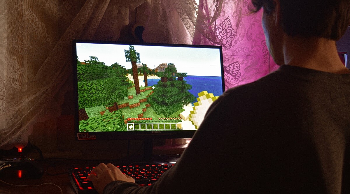 Gamer playing Minecraft on gaming PC.